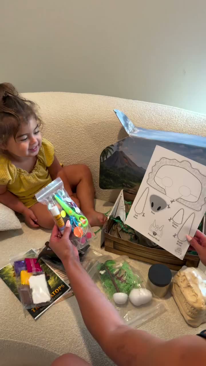 Toddler exploring Quest Club box activities on the couch